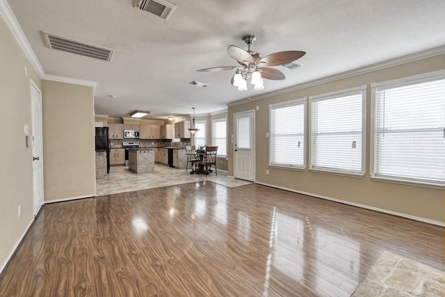 unfurnished living room featuring light wood-style flooring, visible vents, and crown molding