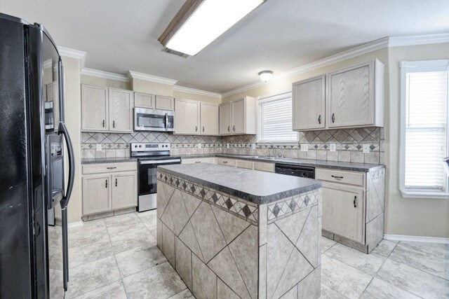 kitchen featuring a center island, visible vents, ornamental molding, a sink, and black appliances