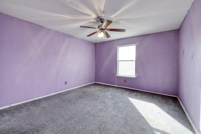 spare room with carpet floors, a ceiling fan, and baseboards