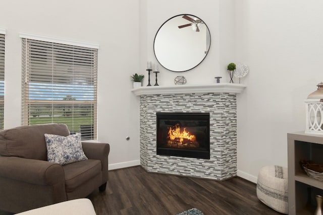 living area with dark wood-style floors, baseboards, and a tiled fireplace