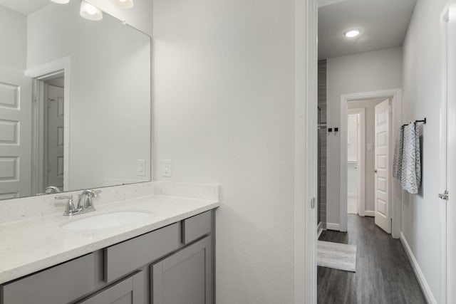 bathroom with vanity, baseboards, and wood finished floors