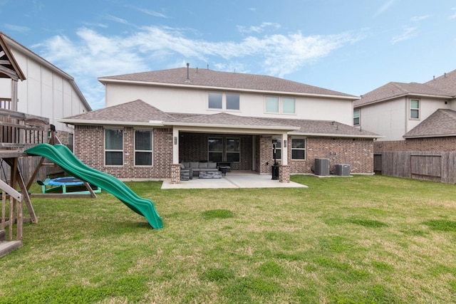 back of house featuring a patio, a playground, a fenced backyard, central AC, and brick siding