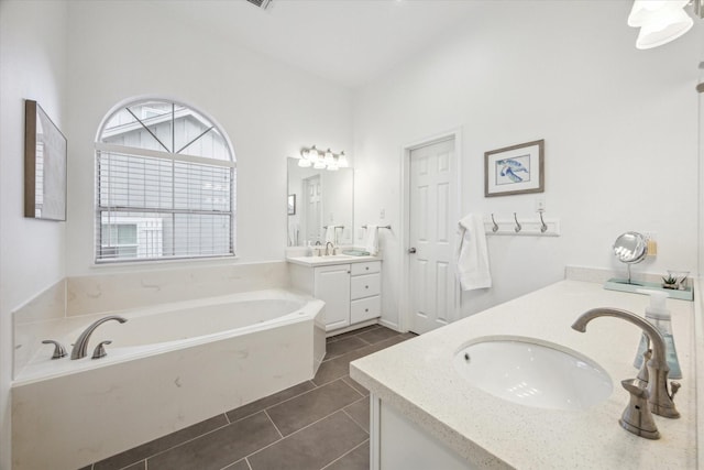 full bathroom featuring a garden tub, vanity, and tile patterned flooring