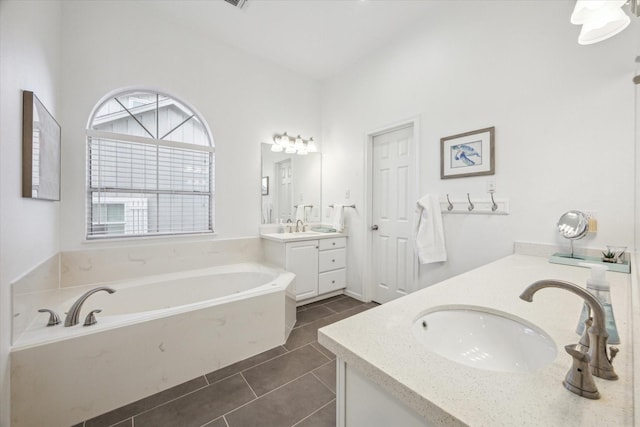 bathroom featuring tile patterned floors, vanity, and a garden tub