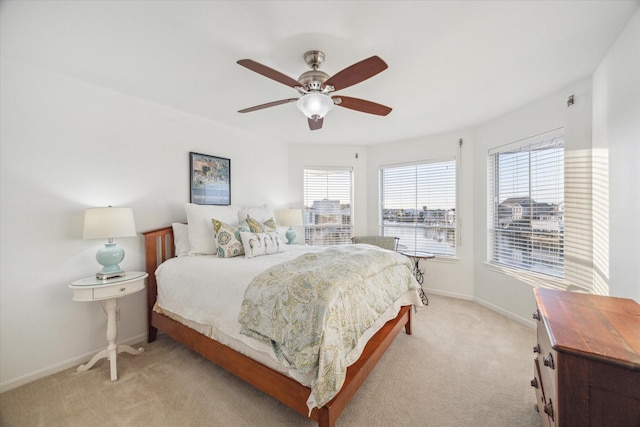 bedroom featuring a ceiling fan, baseboards, and light carpet