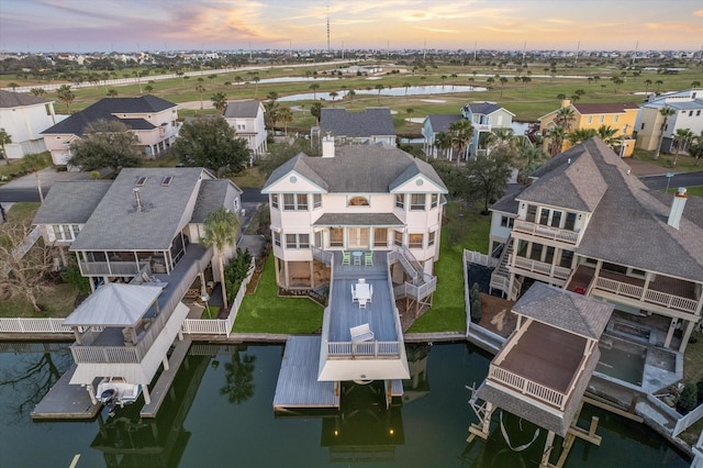 aerial view at dusk with a residential view and a water view