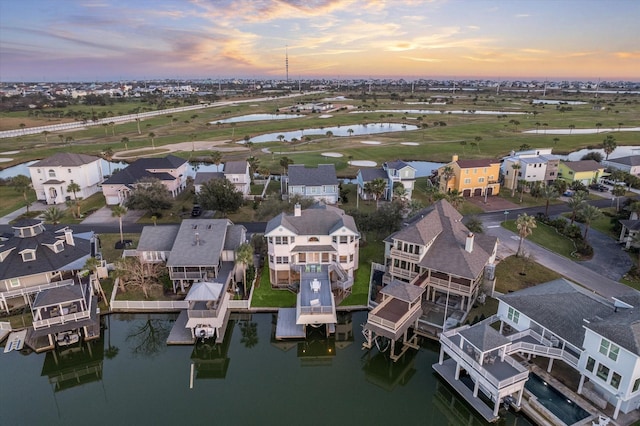 bird's eye view featuring golf course view, a water view, and a residential view