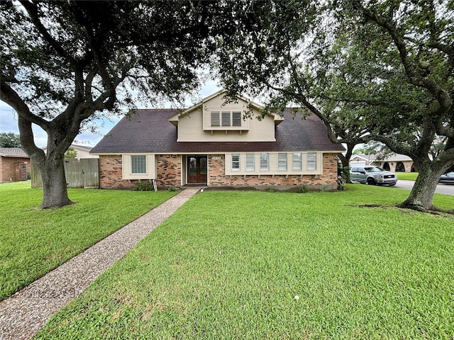 traditional home with brick siding, fence, and a front yard