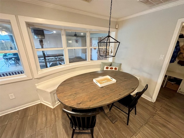 dining area with ornamental molding, an inviting chandelier, baseboards, and wood finished floors