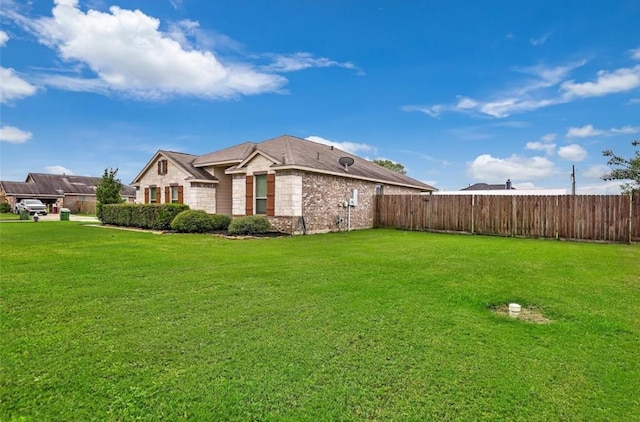 view of side of property with stone siding, brick siding, fence, and a lawn