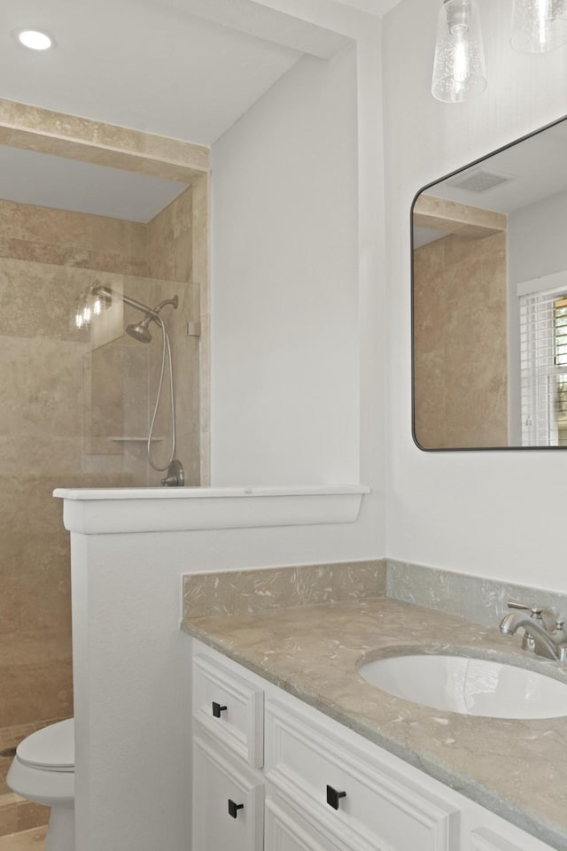 bathroom with toilet, a stall shower, and vanity