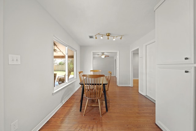 dining space with light wood-style floors, visible vents, and baseboards