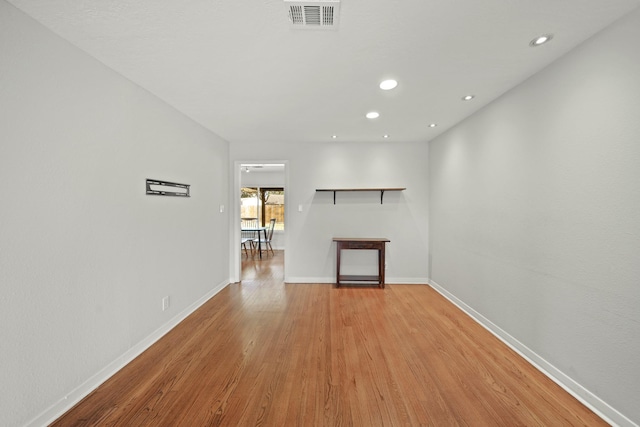 unfurnished living room with light wood finished floors, baseboards, visible vents, and recessed lighting