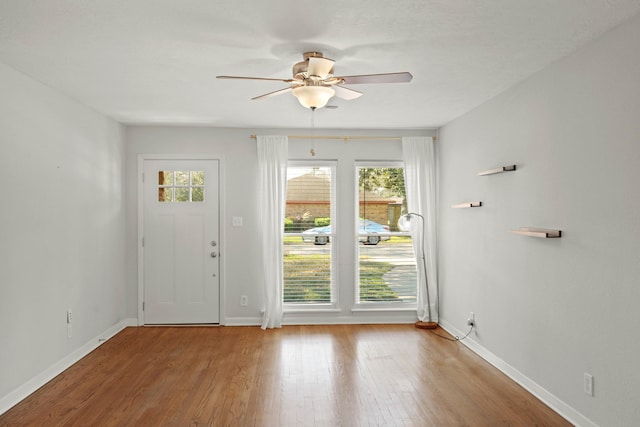 doorway to outside featuring baseboards and wood finished floors