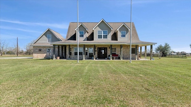 view of front of house with brick siding, fence, a porch, and a front yard