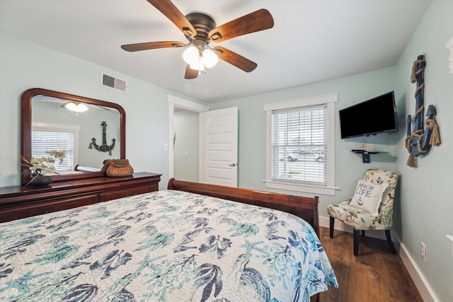 bedroom featuring dark wood-type flooring, a ceiling fan, visible vents, and baseboards