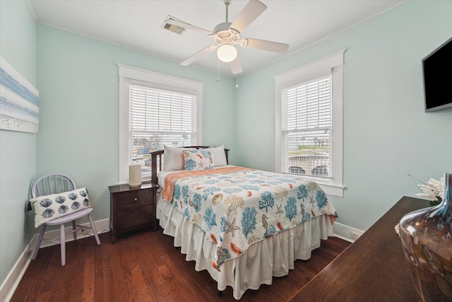 bedroom with a ceiling fan, dark wood finished floors, visible vents, and baseboards