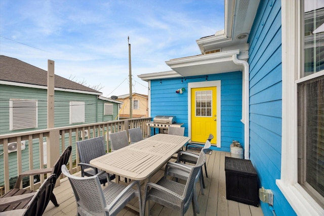 wooden terrace with outdoor dining area and grilling area