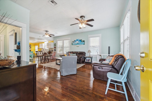 living area featuring dark wood-style floors, visible vents, and a ceiling fan