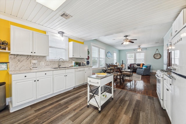 kitchen featuring white appliances, light countertops, a sink, and white cabinets