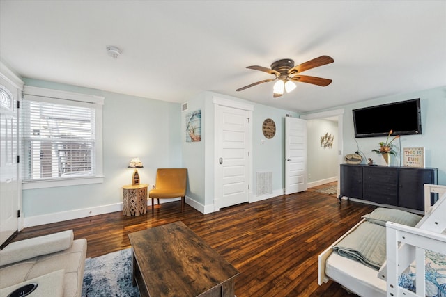 living room featuring a ceiling fan, baseboards, visible vents, and dark wood-style flooring