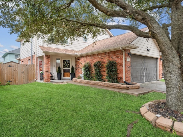 view of front facade with a front yard, a garage, fence, and brick siding