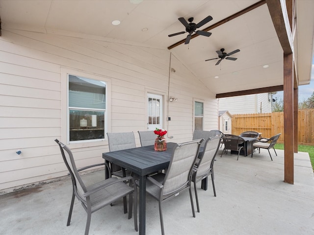 view of patio with outdoor dining space, ceiling fan, and fence