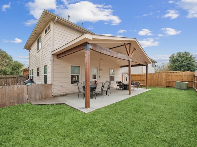 rear view of property with a lawn, a fenced backyard, and a patio area