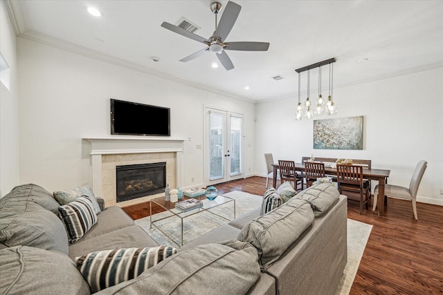 living area with dark wood-style floors, ornamental molding, visible vents, and baseboards