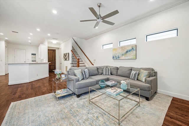 living room featuring ornamental molding, stairway, baseboards, and wood finished floors