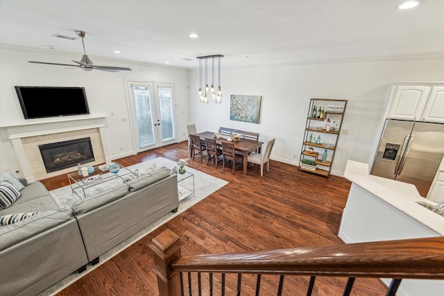 living area with dark wood-style floors, french doors, visible vents, and crown molding