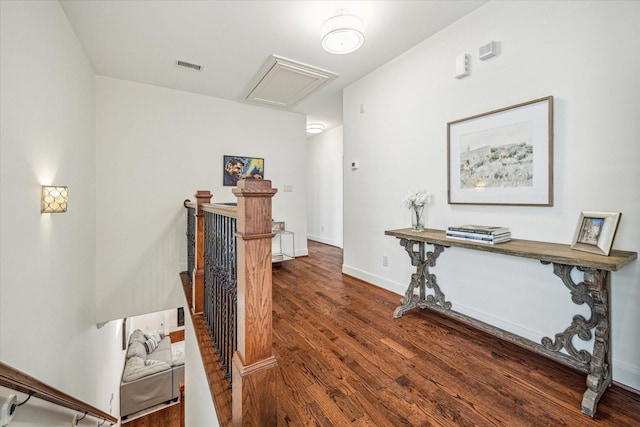 interior space with baseboards, visible vents, dark wood finished floors, and an upstairs landing