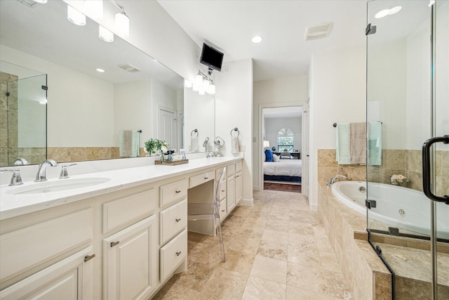 ensuite bathroom with double vanity, ensuite bath, a sink, and a jetted tub