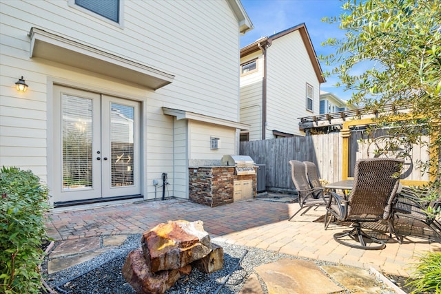 view of patio with french doors, grilling area, an outdoor kitchen, and fence