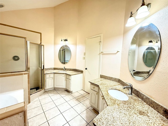 bathroom with a shower stall, two vanities, a sink, and tile patterned floors