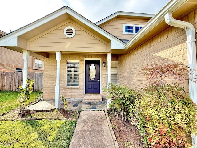 property entrance with brick siding and fence