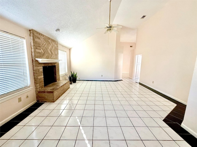 unfurnished living room featuring lofted ceiling, light tile patterned floors, a textured ceiling, a fireplace, and visible vents