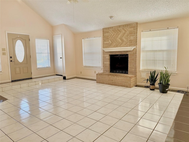 unfurnished living room featuring light tile patterned floors, a textured ceiling, lofted ceiling, baseboards, and a brick fireplace