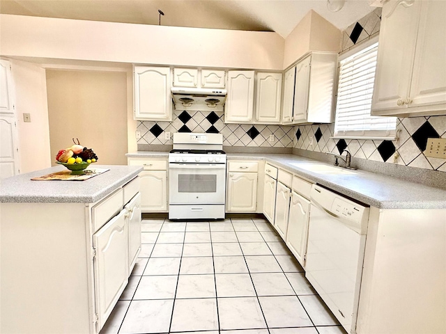 kitchen with white appliances, tasteful backsplash, light tile patterned floors, light countertops, and a sink