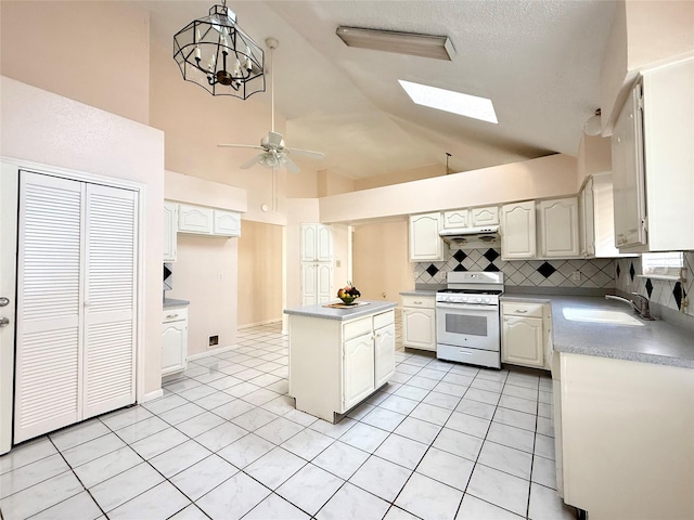 kitchen with a sink, white cabinets, hanging light fixtures, light countertops, and white gas range oven