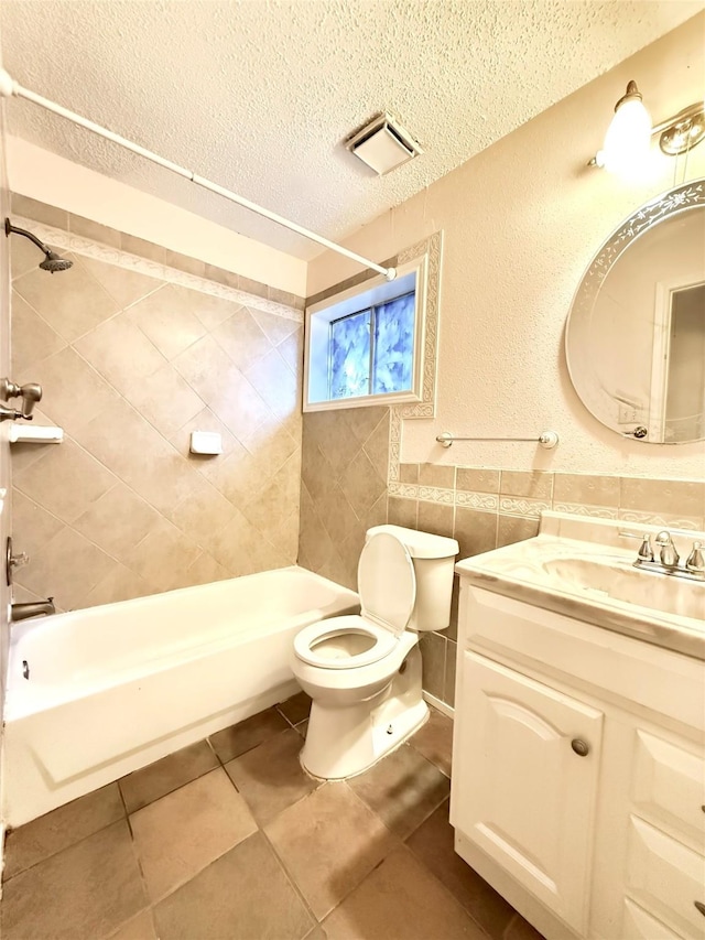 bathroom featuring toilet, tub / shower combination, a textured ceiling, vanity, and tile walls