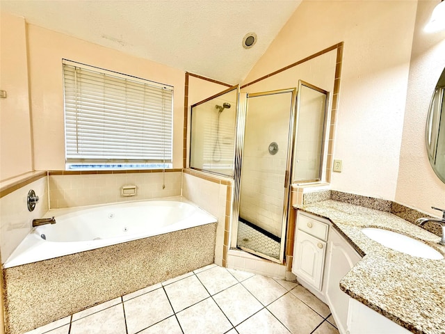 bathroom featuring a textured ceiling, vanity, vaulted ceiling, a shower stall, and tile patterned floors