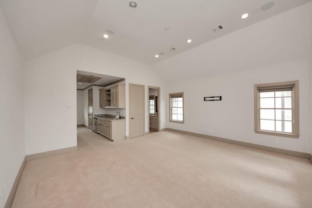 unfurnished living room featuring baseboards, visible vents, vaulted ceiling, and light colored carpet