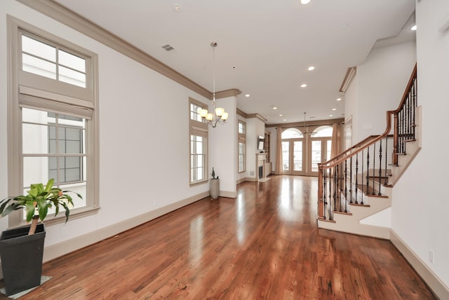 entryway with baseboards, wood finished floors, stairs, crown molding, and french doors