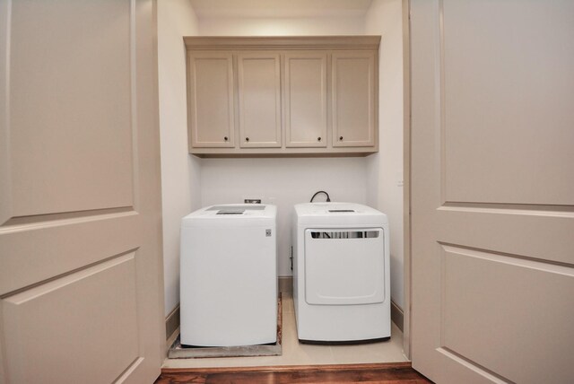 314 W Clay St, Houston, TX 77019 - laundry area featuring washing machine and clothes dryer, cabinet space, and wood finished floors