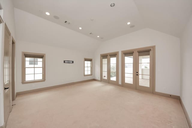 unfurnished room featuring french doors, lofted ceiling, light colored carpet, visible vents, and baseboards