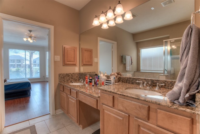 full bathroom with double vanity, connected bathroom, visible vents, and a sink