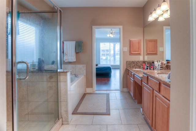 bathroom featuring double vanity, tile patterned floors, ensuite bathroom, a sink, and a bath