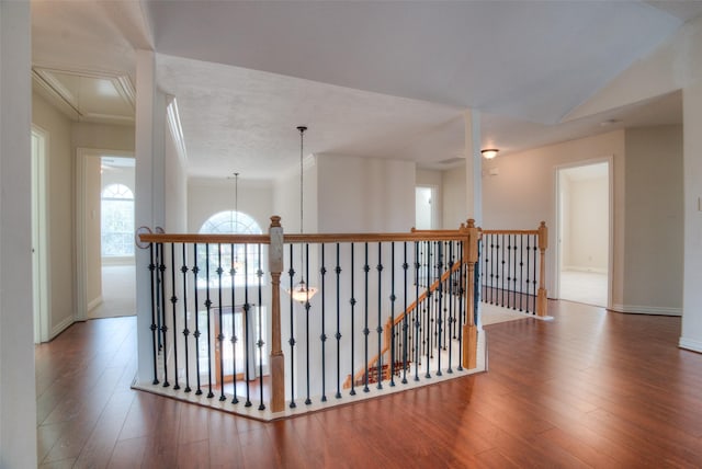 hall with attic access, baseboards, an upstairs landing, and wood finished floors