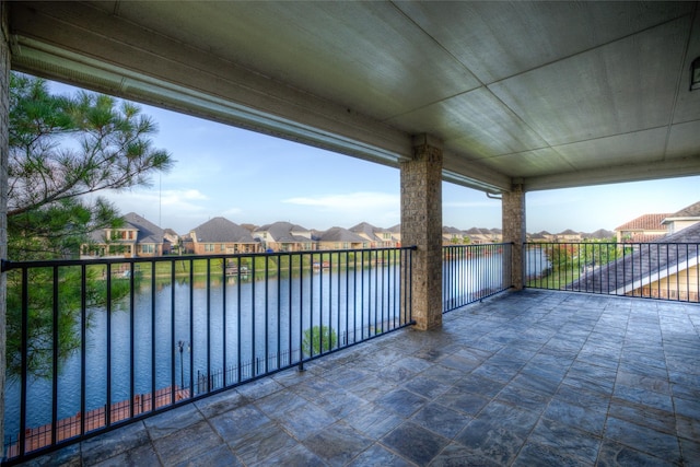 view of patio / terrace featuring a water view, a balcony, and a residential view